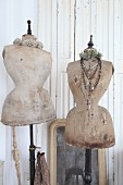 Two old tailors' dummies draped with rosaries