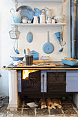 Feuer im Küchenofen und alte Küchenutensilien aus Emaille