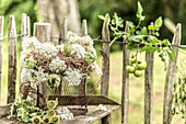 Wreath of hay and Queen Anne's lace in front of paling fence