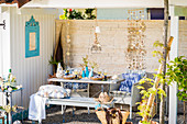 Set table and summery decorations on terrace with stone wall
