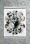 Paper artwork decorated with snowdrops and black feathers