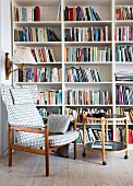 Checked armchair and round side table in front of bookcase