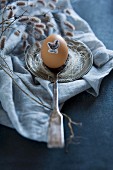 Egg decorated for Easter with animal sticker on silver spoon