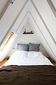 Bedroom in narrow gable room with steeply sloping ceiling