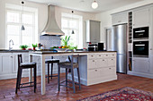 Island counter with breakfast bar in bright country-house kitchen