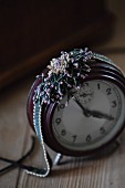 Glass-bead jewellery on vintage alarm clock