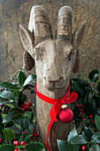 Wooden ibex decorated with wreath of holly, ribbon and bauble