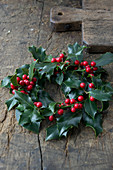 Christmas holly wreath on wooden table