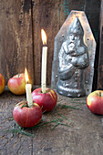 Candles in red apples in front of chocolate mould