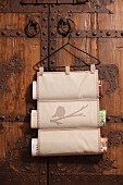 Hand-sewn magazine rack hanging from vintage coat hanger on wooden door