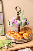 Pastries on vintage cake stand and green and lilac Easter ornaments