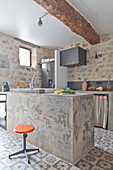 Exposed stone walls, beams and masonry counter in rustic kitchen