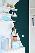 Shelving on white wall with teal triangle