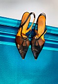 Shoes hung from picture rail on blue wall