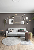 Pictures and ornaments on grey wall above sofa