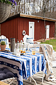 Tisch mit blau-weisser Tischdecke auf der Terrasse