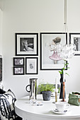 Black-framed pictures above round dining table
