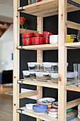 Crockery and storage containers on simple wooden shelves