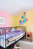 Metal bed against two-tone walls in child's bedroom
