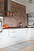 Brick wall in white kitchen