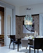 Set dining table below modern glass ceiling lamp