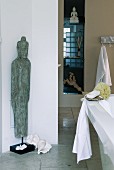 Exotic statue and natural ornaments in white and beige bathroom