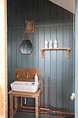 Rustikales Badezimmer mit Kupferrohren an blauer Bretterwand