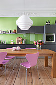 Dining table in kitchen with grey cabinets, green wall and stucco ceiling
