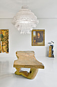 Rustic wooden table and modern artworks in white interior