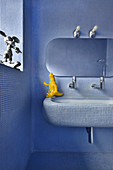 Blue mosaic tiles covering all surfaces in bathroom with rounded edges