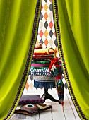 Colourful arrangement of accessories seen through green curtains