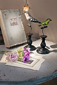 Vintage-style arrangement of book, stuffed birds and flowers on table