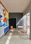 Colourful mural in austere dining room in artist's house