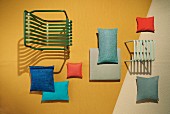 A garden chair and stool with decorative cushions made from UV and water-resistant fabrics