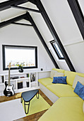 Yellow sofa in attic room with steel roof beams