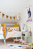 Babybett und Tierfiguren im Dachgeschoss-Kinderzimmer