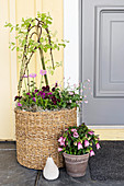 Spring flowers in basket and flower pot next to front door