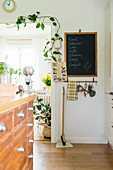 Chalkboard next to climbing plant in open doorway leading into kitchen