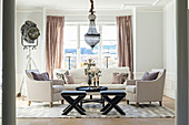Elegantes Wohnzimmer mit hellen Polstermöbeln und Kronleuchter