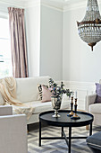 Pale sofa set and chandelier in elegant living room