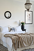 Fur blanket on bed in elegant black and white bedroom