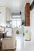 Wohnküche im eleganten Landhausstil mit weißem Holzboden