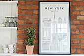 Picture of New York on brick wall next to shelving