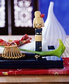 Japanese Kokeshi doll and green calla lily on black lacquered tray