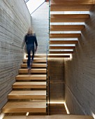 Woman walking up floating wooden staircase