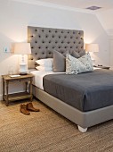 Sisal rug and grey button-tufted headboard in bedroom