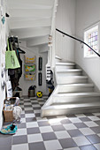 Chequered floor in rustic foyer with winding staircase