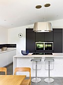 Counter and bar stools in minimalist designer kitchen