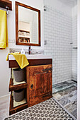 Old vanity unit in the bathroom with white subway tiles