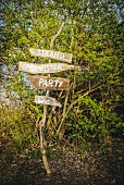 Rustic hand-made signpost with lettering on wooden boards for summer party